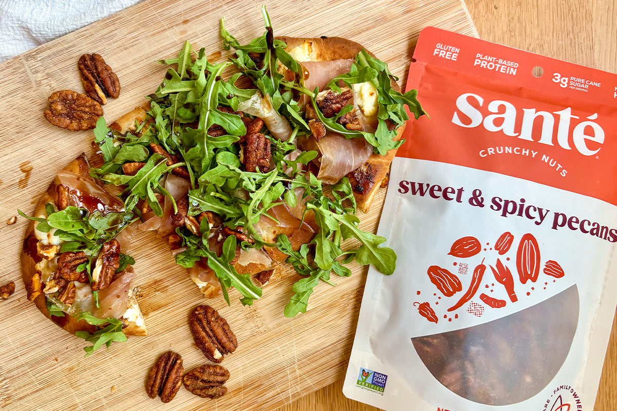 Baked flatbread with prosciutto, goat cheese, arugula, balsamic glaze, and Santé Nuts Sweet & Spicy Pecans