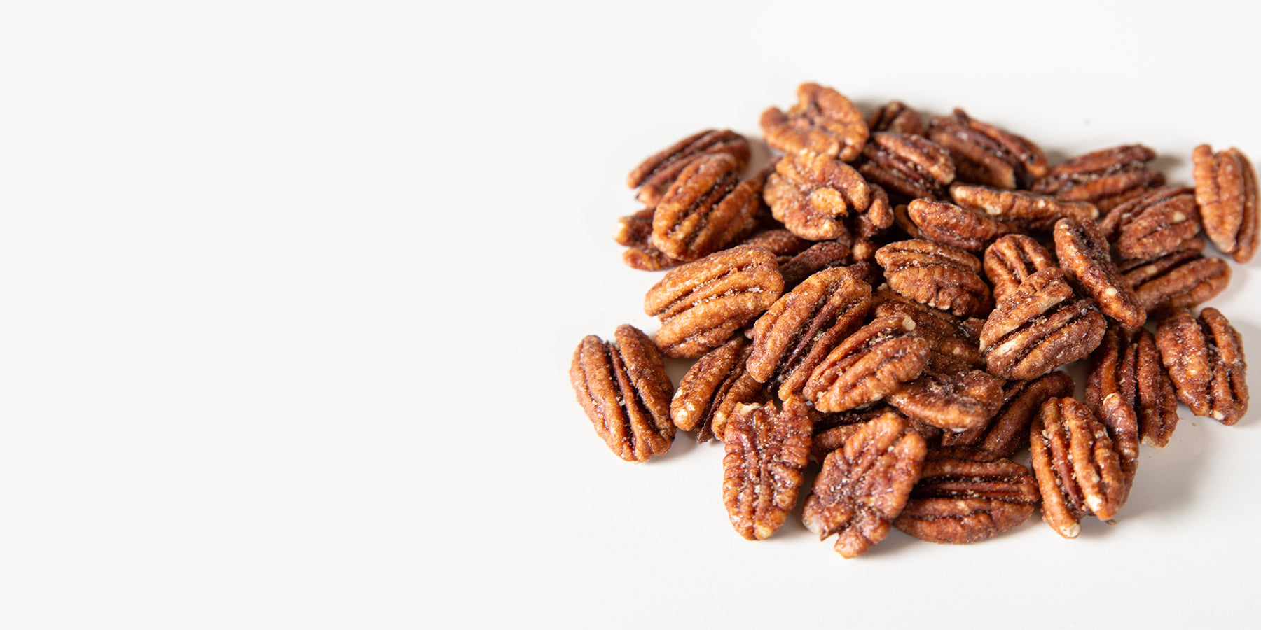A pile of candied pecans on white background